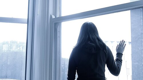 A woman looking out a window.