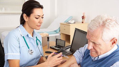 A nurse giving an injection to an old man.